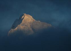 The very top of Cholatse rises above the mist in the evening.